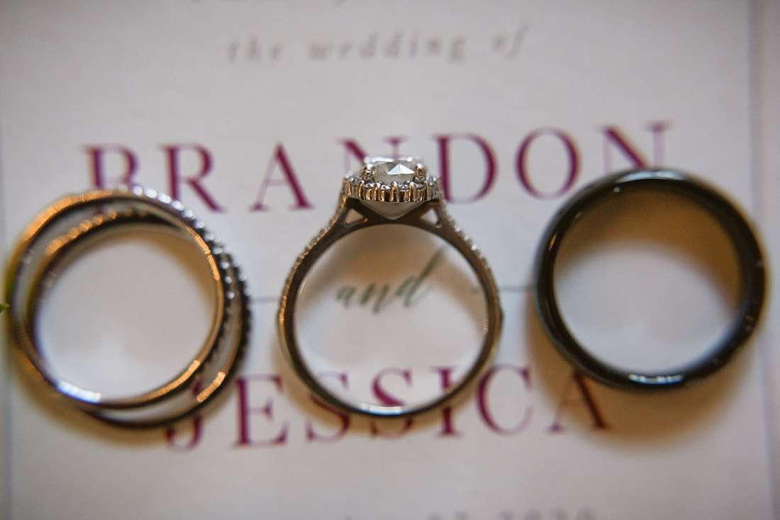 close up picture of wedding rings on wedding invitation at the wedding barn in arkansas