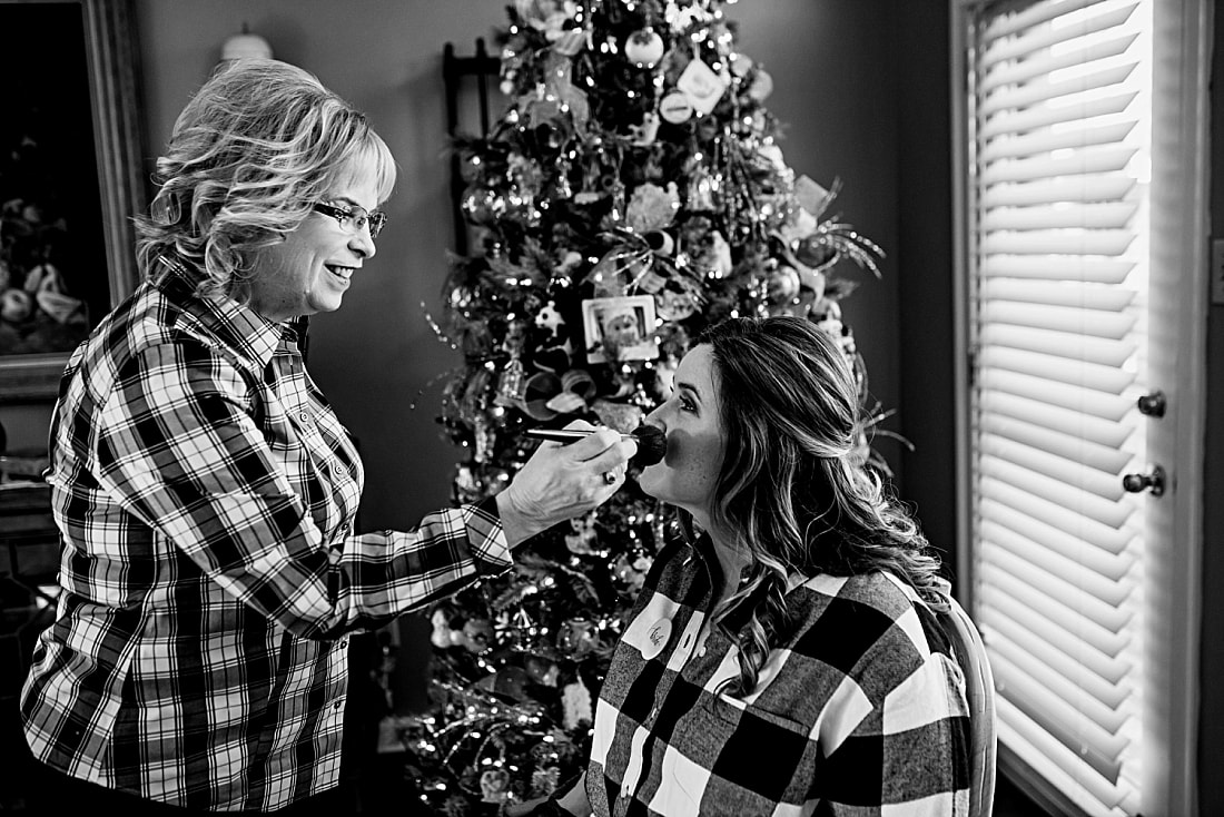 Bride having her makeup done in front of the Christmas tree in Collierville, TN