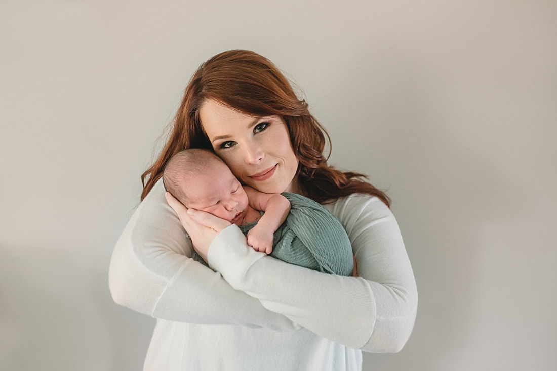 mother hold newborn baby boy for newborn portraits in memphis tn