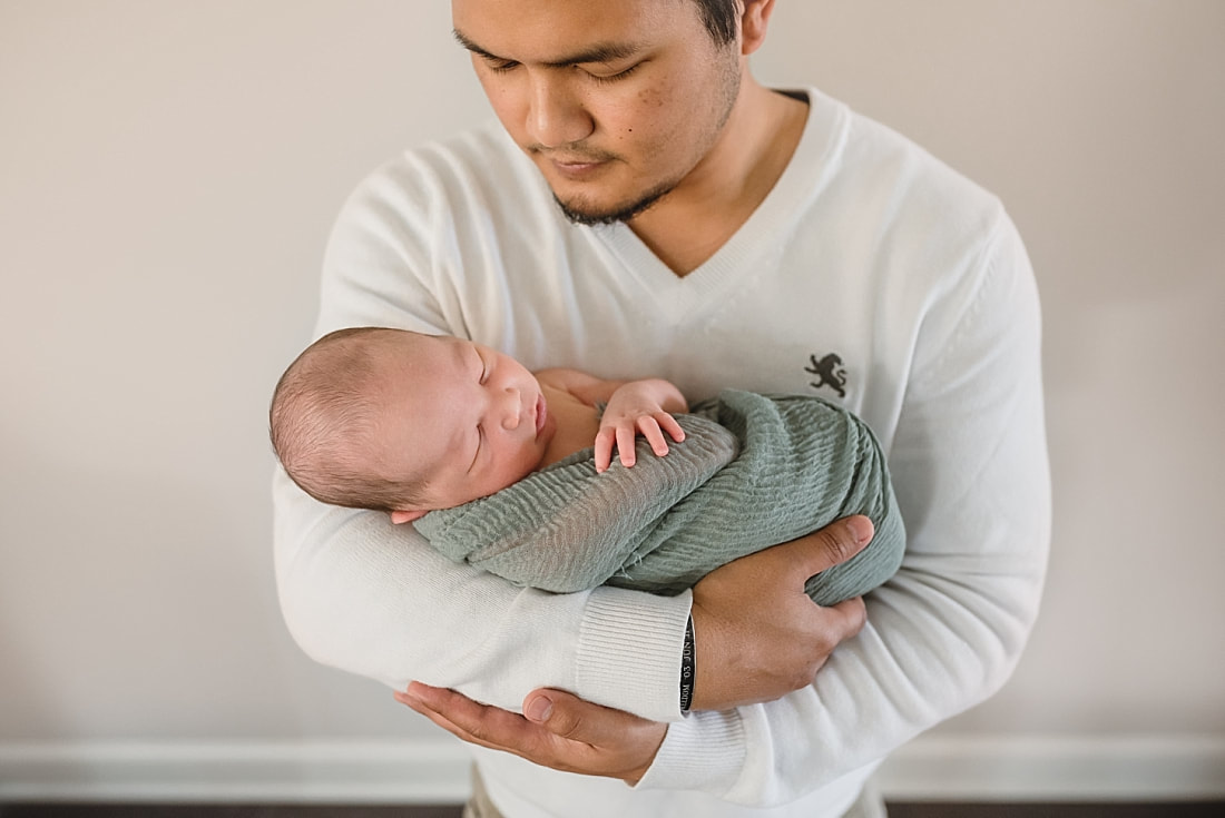 father holding newborn baby boy for newborn portraits in memphis tn