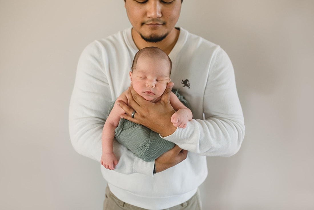 father holding newborn baby boy for newborn portraits in memphis tn