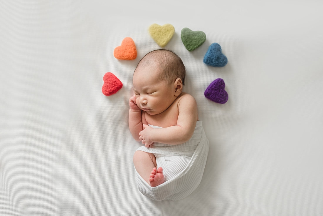 rainbow baby photo, newborn baby boy wrapped in white with rainbow hearts for newborn photo shoot in memphis tn