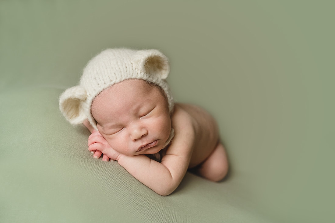 adorable newborn baby boy wearing teddy bear bonnet during memphis newborn photo shoot