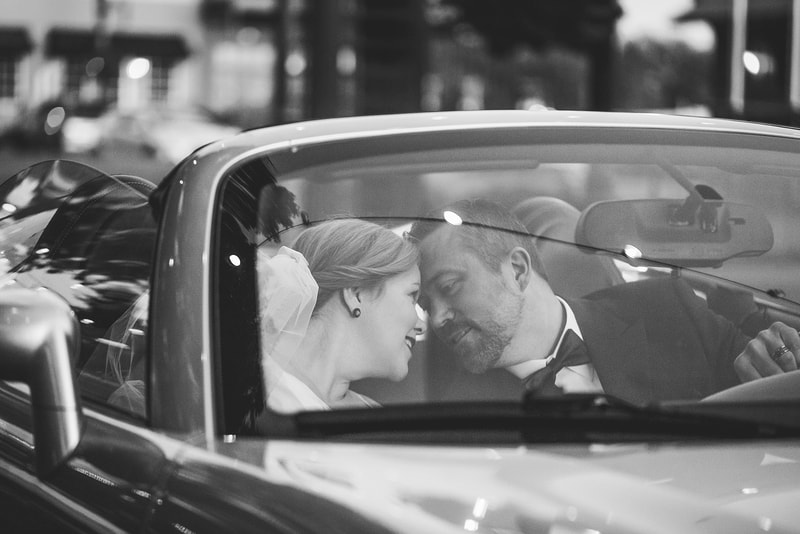 Bride and Groom snuggling in their wedding getaway car at the Collierville Town Square