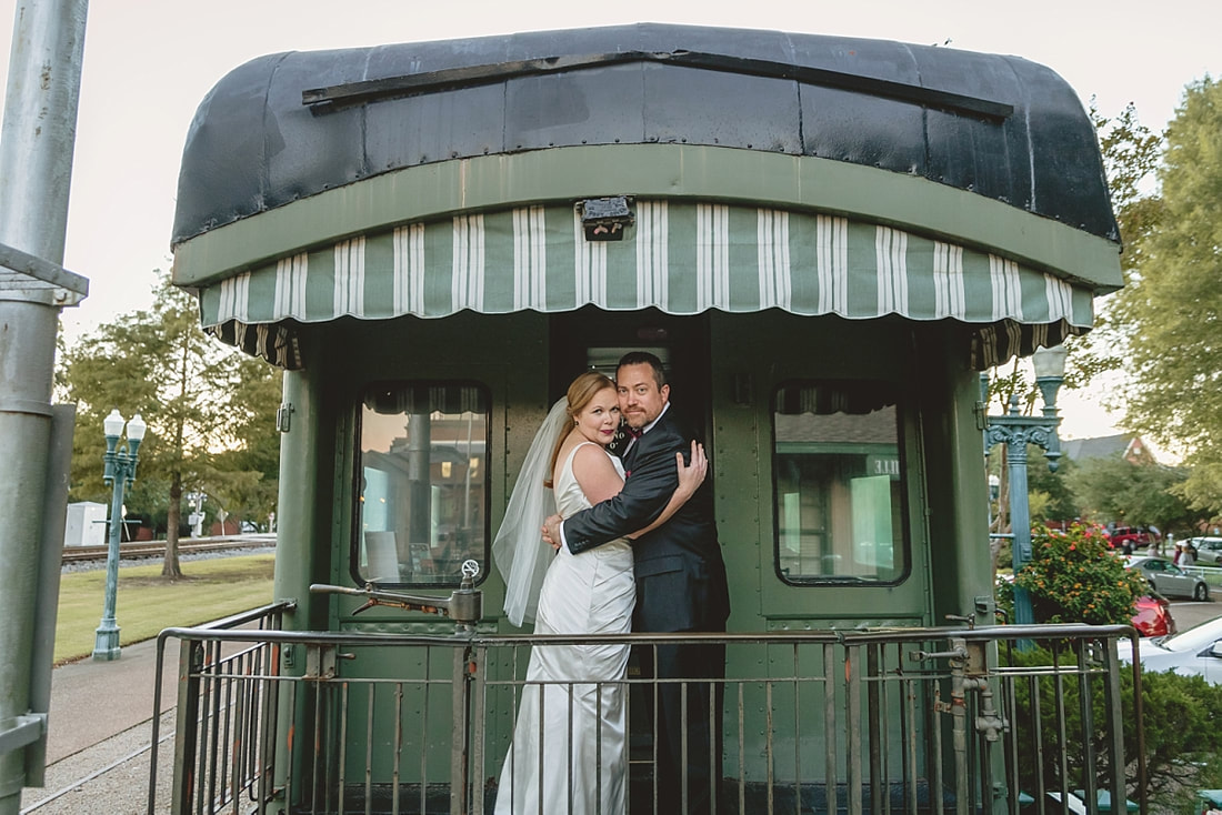 Bride and groom posing on the train after their wedding ceremony at the Collierville Town Square