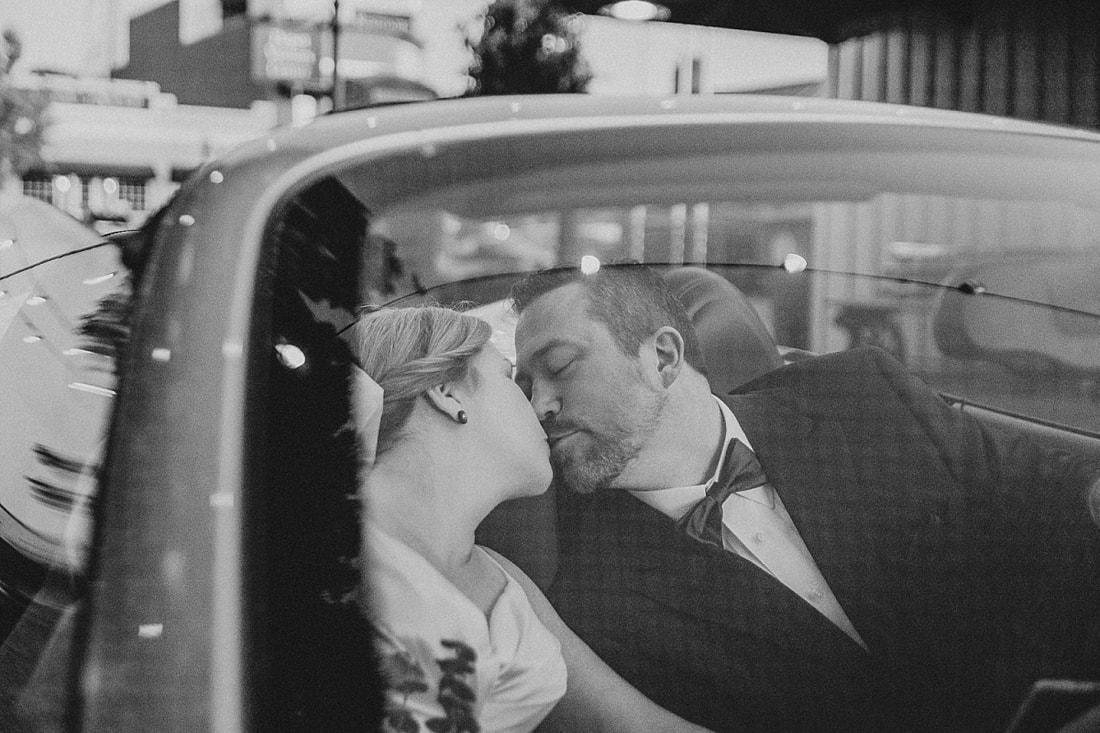 Bride and Groom kissing in their getaway car at the Collierville Town Square