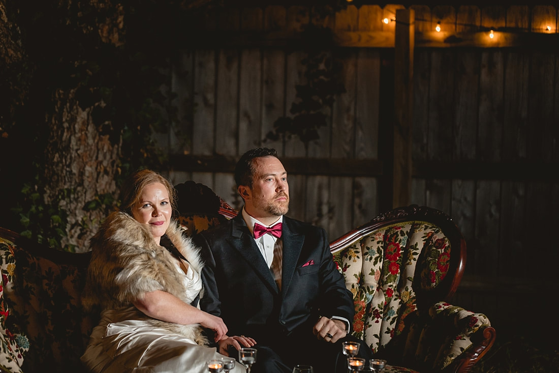 bride and groom pose on antique floral couch at collierville wedding reception 