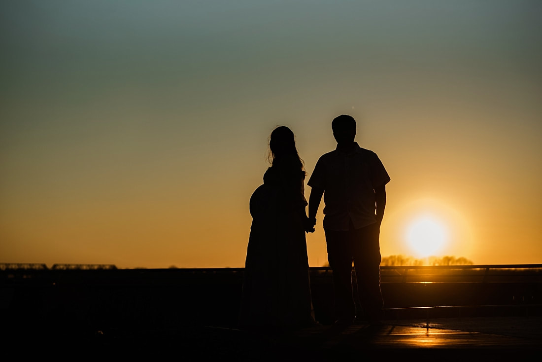 silhouette of husband with pregnant wife at the mississippi river downtown memphis