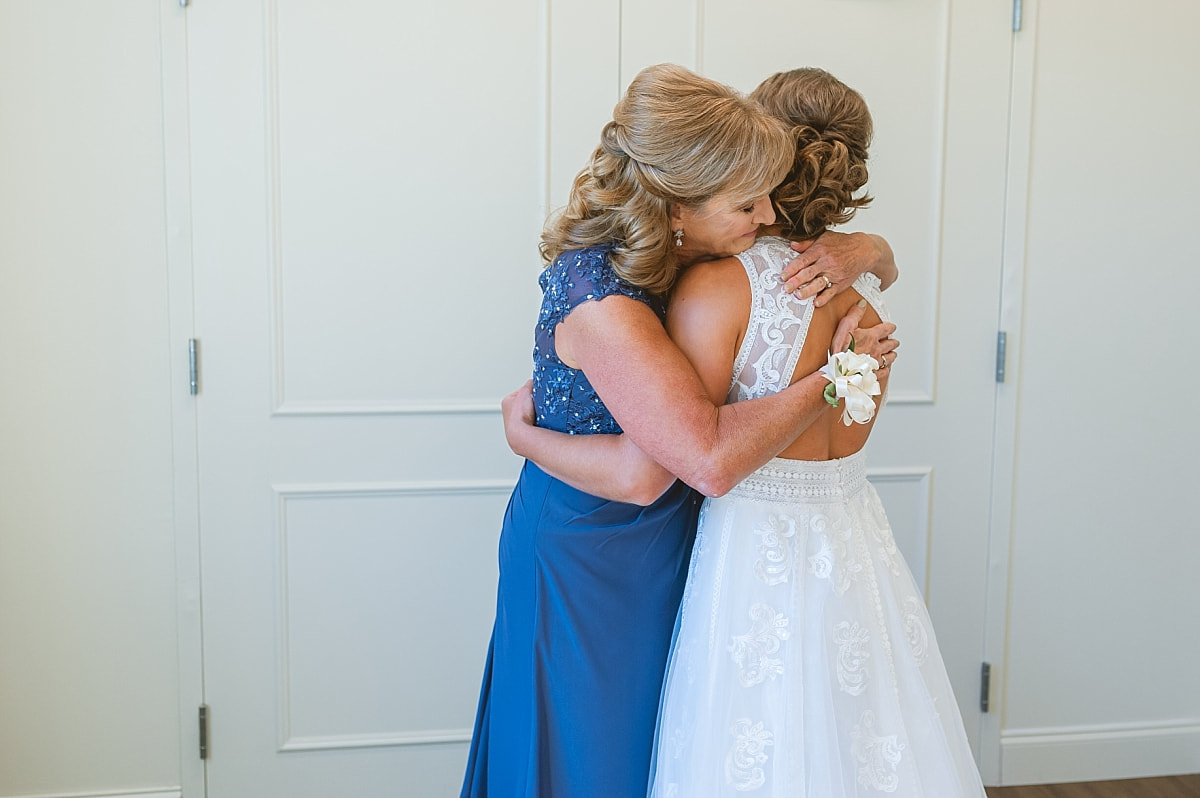 bride and mother of the bride hugging
