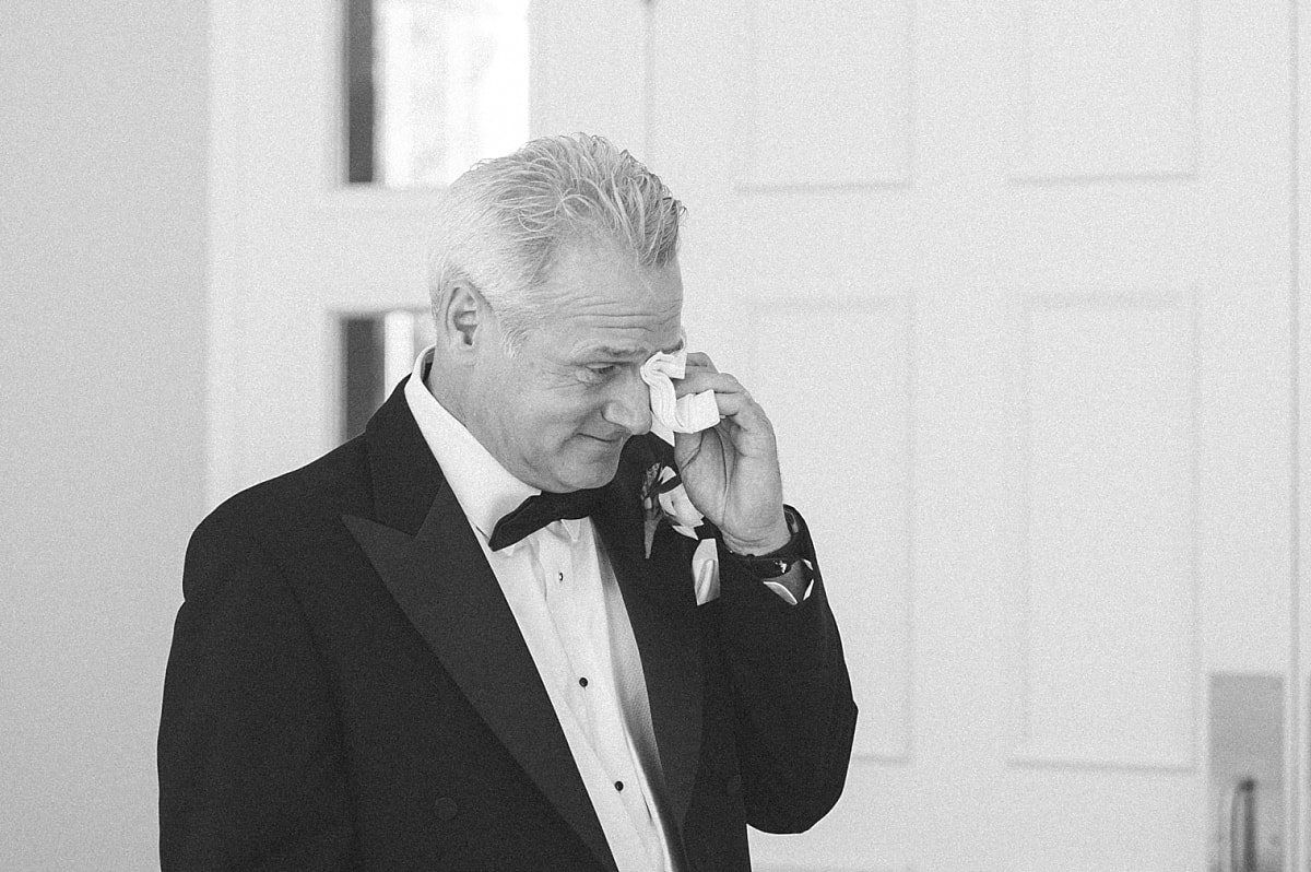 father of the bride wiping away tears after seeing his daughter as a bride for the first time