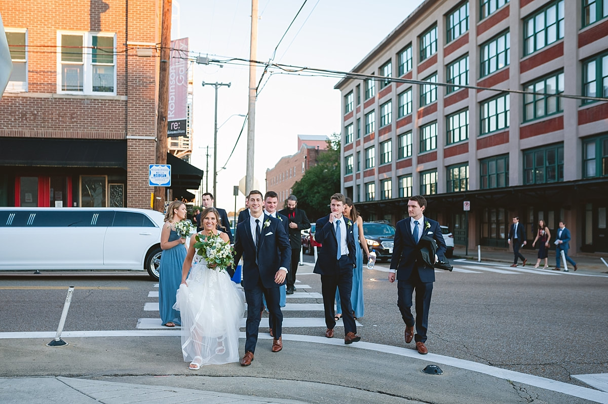 bride and groom walking downtown with their wedding party downtown memphis