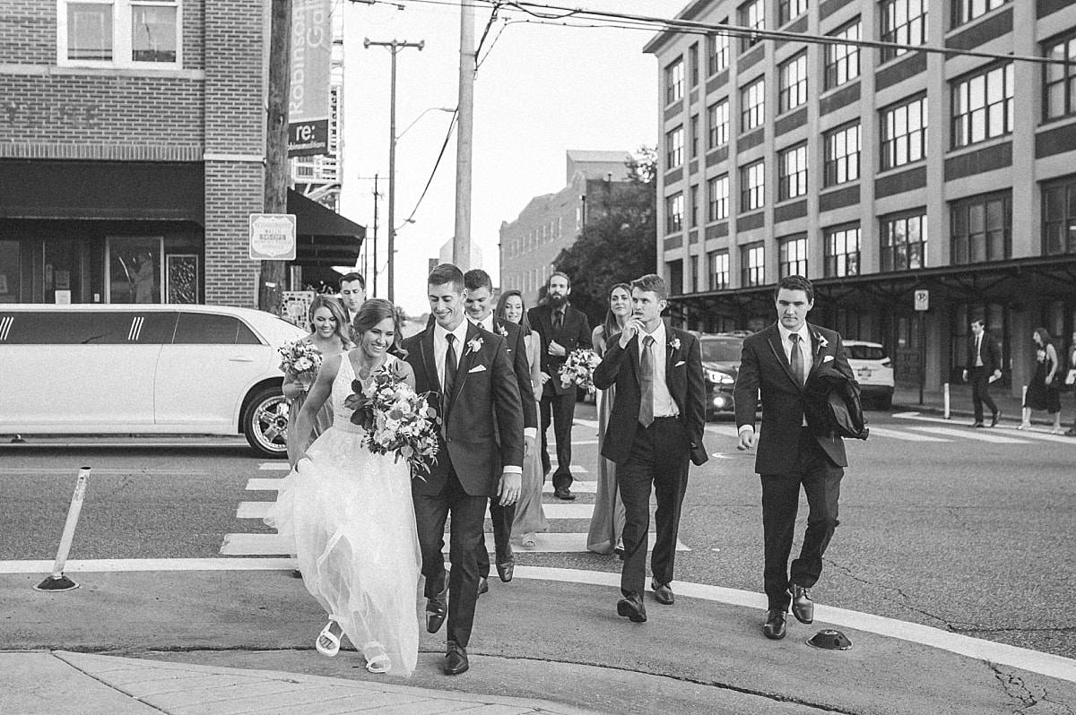 bride and groom walking downtown with their wedding party downtown memphis