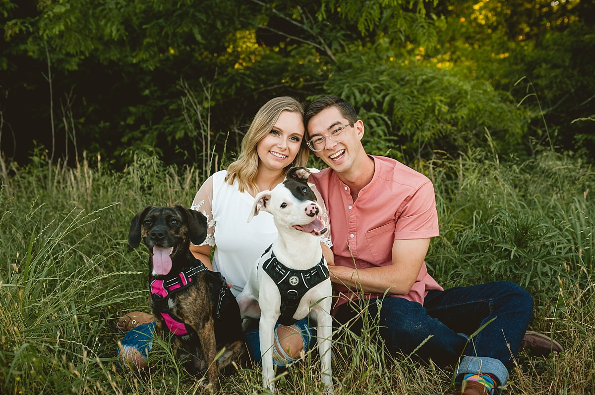 couple posing with their dogs for engagement photos at shelby farms park in memphis, tn