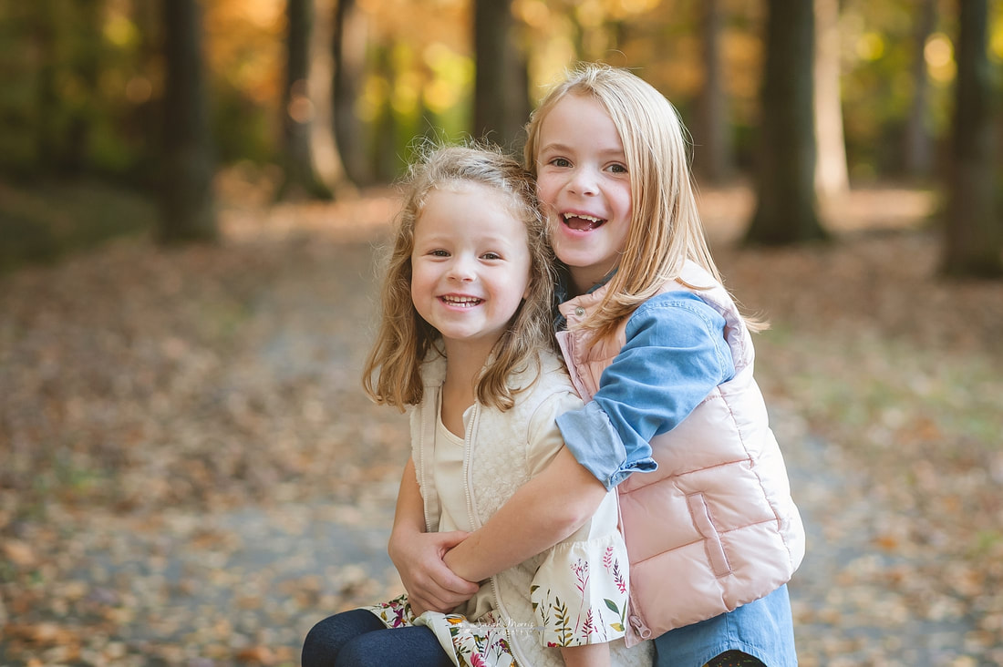 sisters hugging each other during fall family photo session in collierville, tn