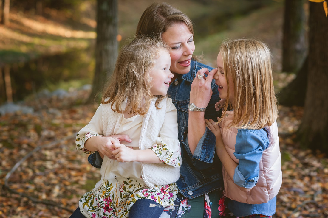 mother loving on her daughters during fall family photo session 