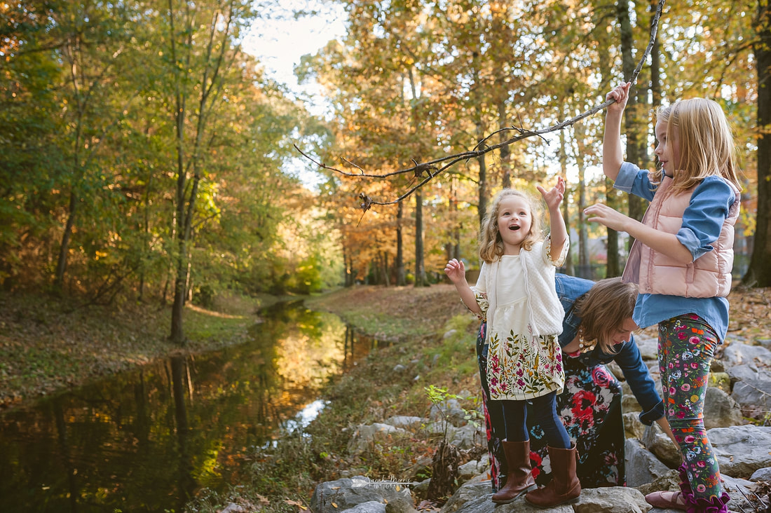 kids throwing sticks in the creek during fall mini session
