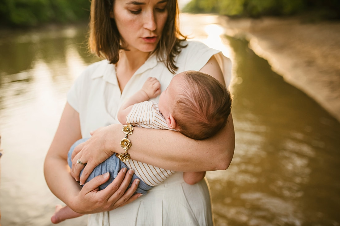 mother holding newborn baby at the Wolf River in Memphis, TN