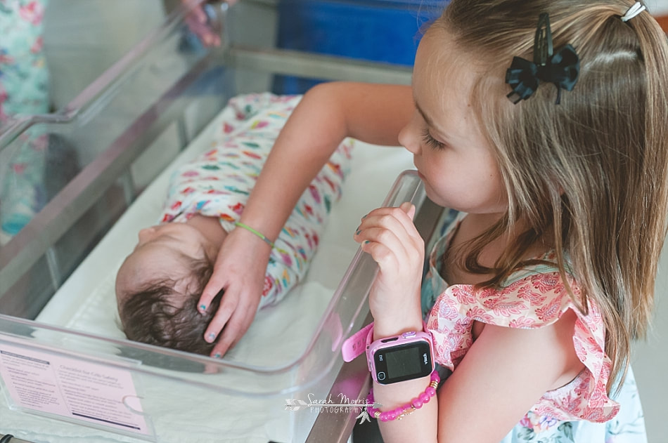 Big sister touching newborn baby sister at Methodist Le Bonheur Germantown Hospital