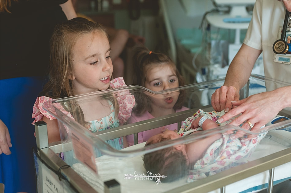 big sisters watching pediatric nurse check on their newborn baby sister at Methodist Le Bonheur Germantown Hospital