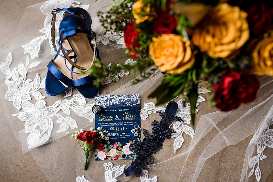 wedding details, including wedding invitation, wedding rings, bridal bouquet, blue wedding shoes, wedding veil at Green Frog Farm