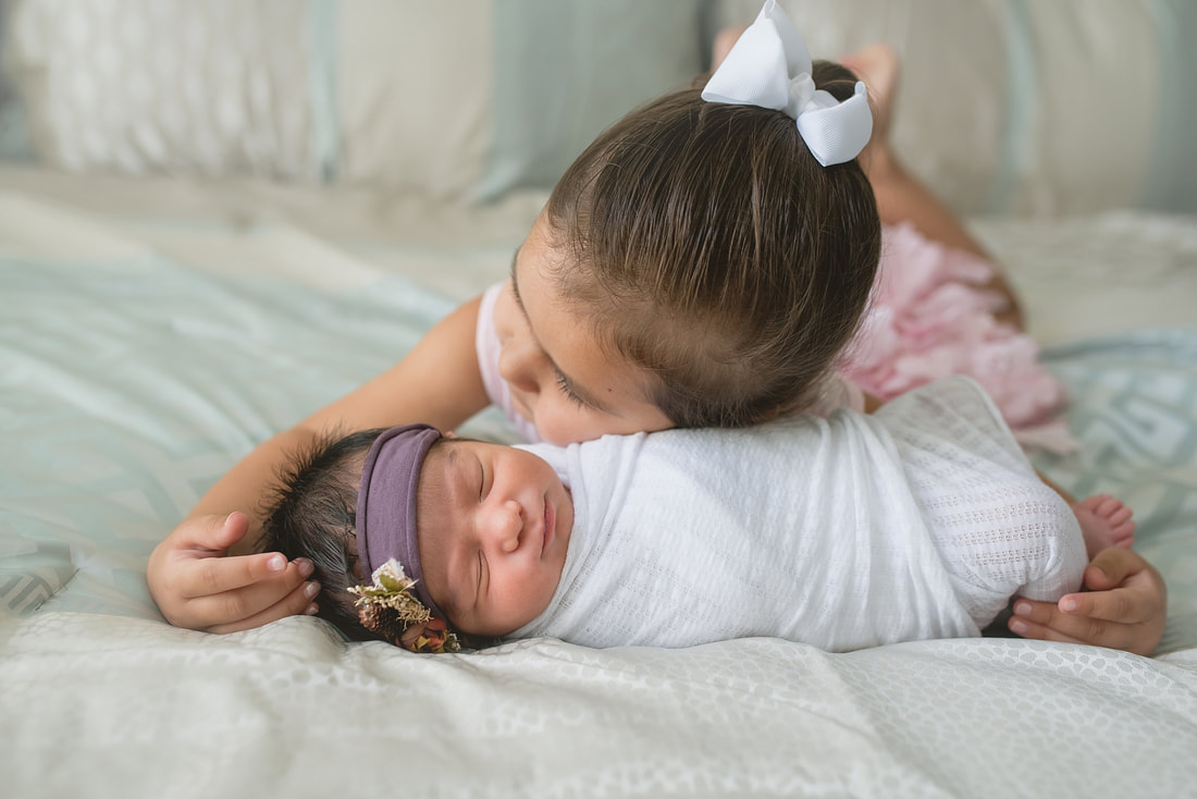 big sister with newborn baby sister during newborn session in memphis, tn