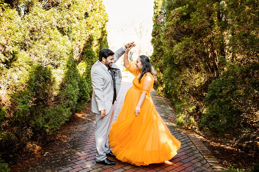 mother and father dancing during maternity photo session at memphis botanic garden
