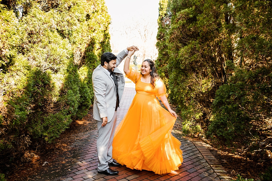 mother and father dancing during maternity photo session at memphis botanic garden