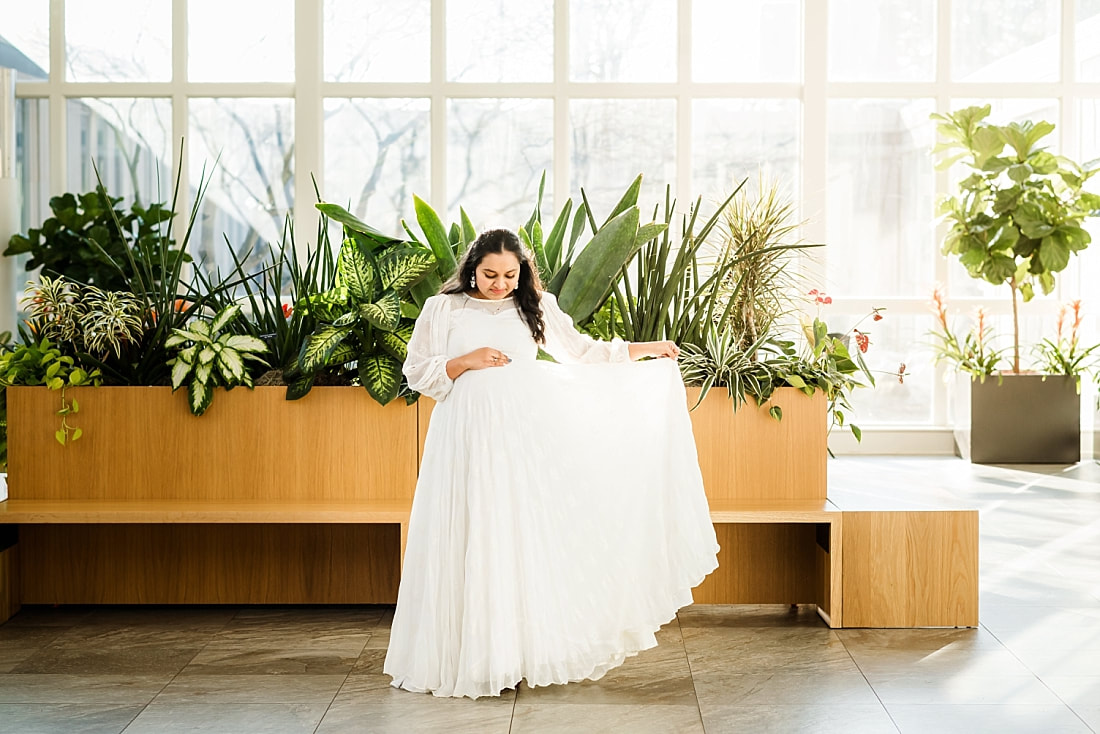 maternity portrait of mother wearing white indian dress in greenhouse at memphis botanic garden