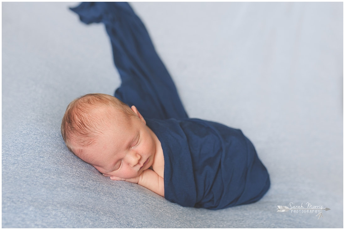 Newborn photos of baby boy sleeping on blue blanket