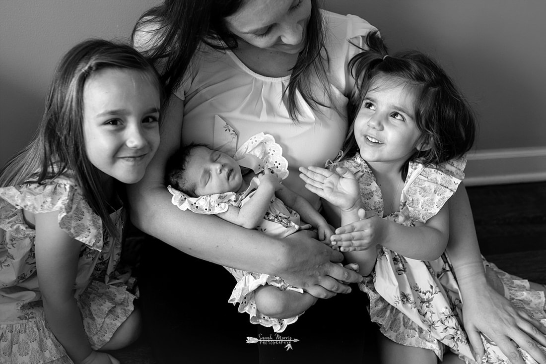 black and white conversion of mom snuggling with all 3 of her daughters