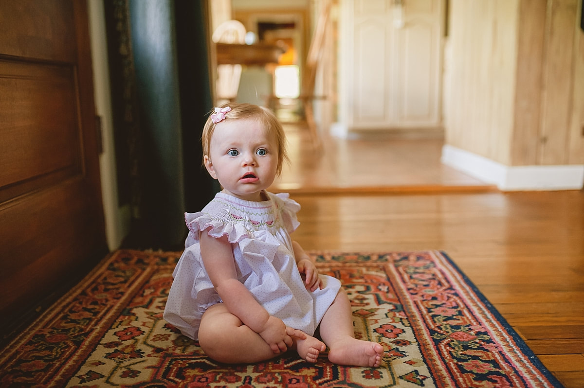 baby girl wearing a beautiful smocked bubble during in home lifestyle family session in collierville, tn