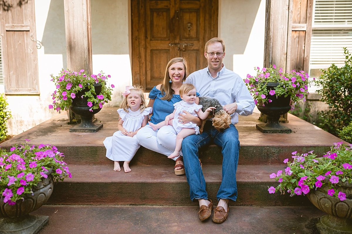 family portrait on the front porch with purple pentunias during in home lifestyle family session in collierville, tn