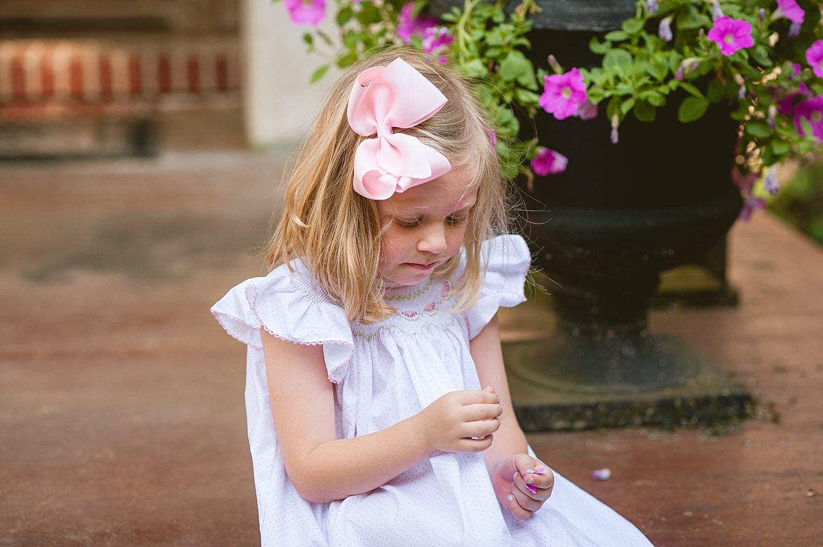 little girl admiring her purple flower during in home lifestyle family session in collierville, tn