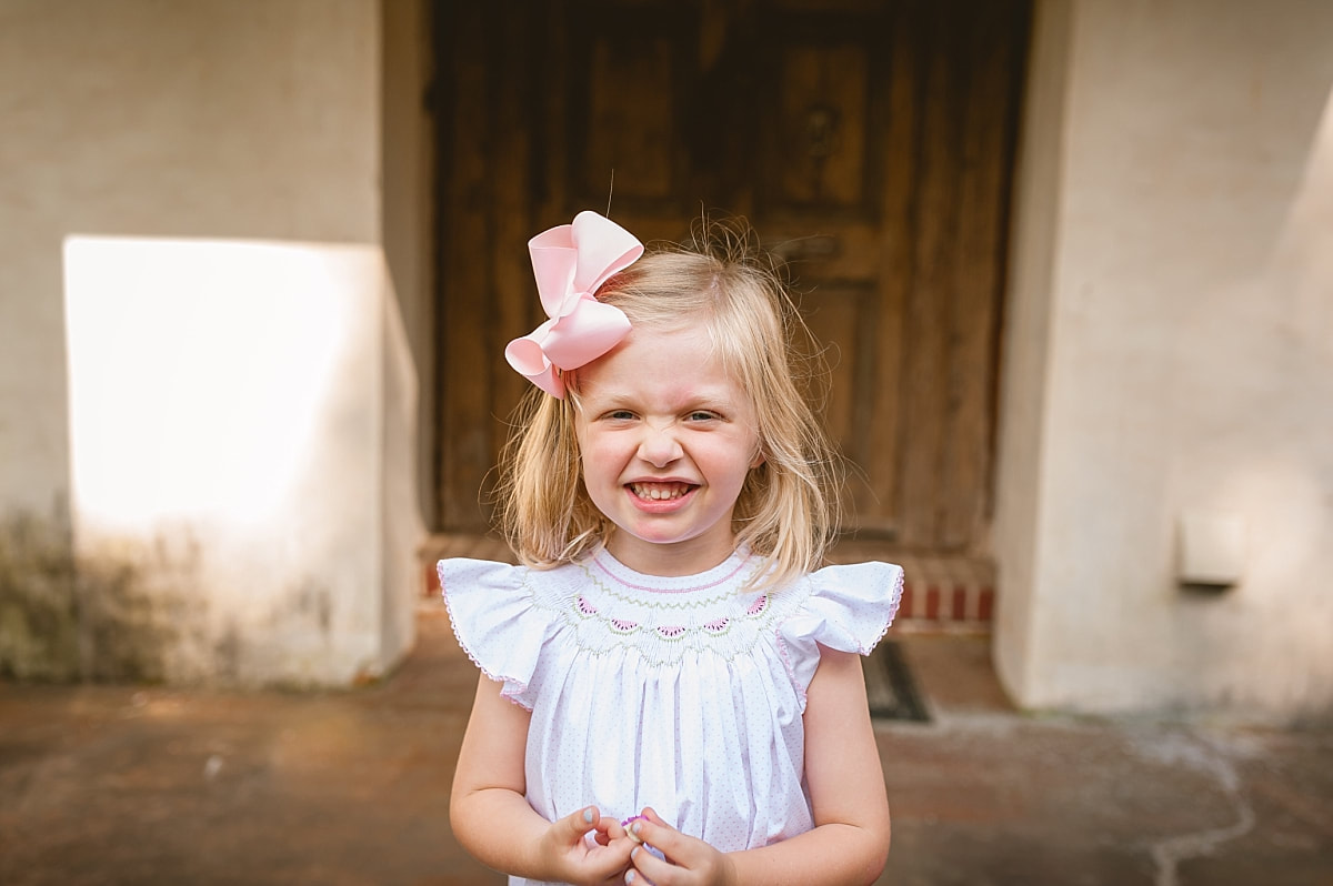 little girl smiling so big and scrunching her nose during in home lifestyle family session in collierville, tn