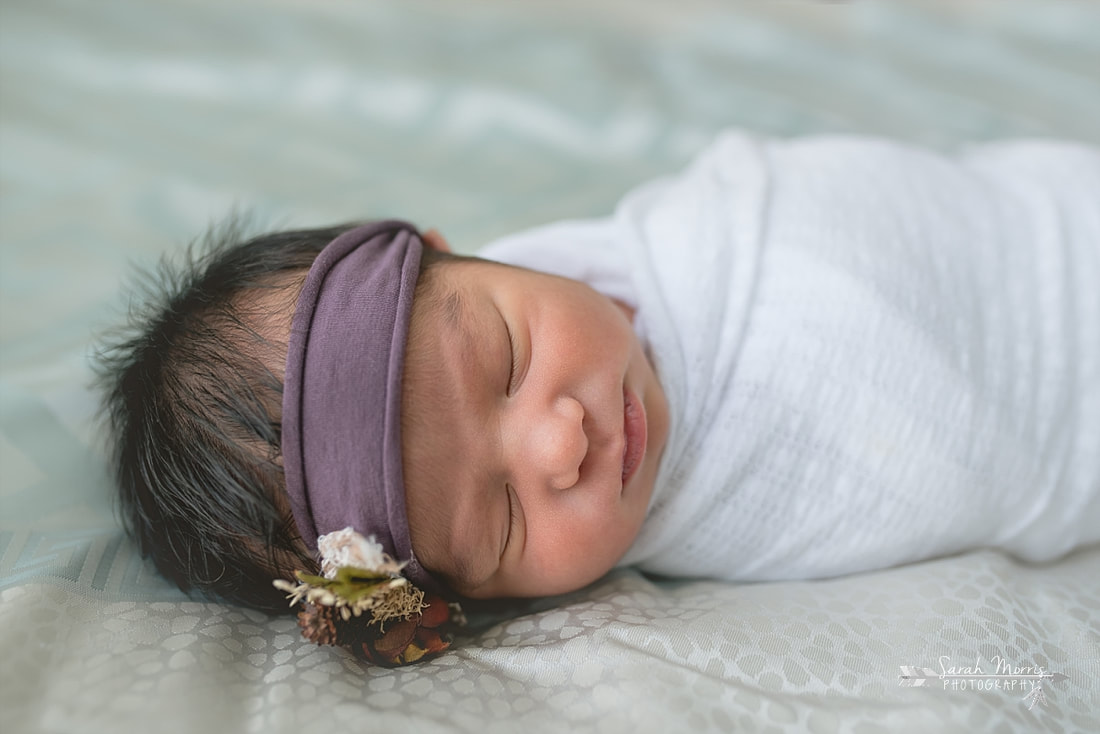Baby sister sleeping on the bed for the lifestyle portion of her newborn photo session