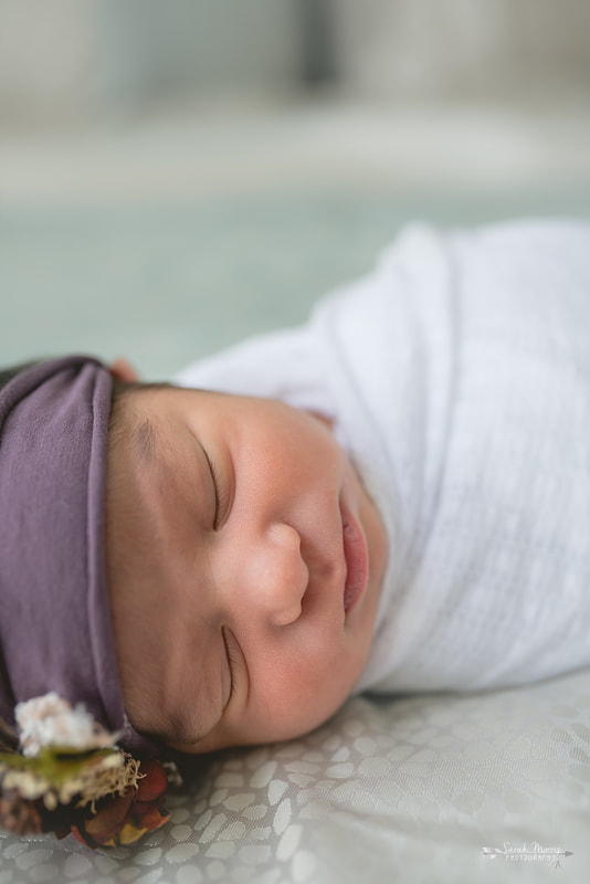 Baby sister sleeping on the bed for the lifestyle portion of her newborn photo session