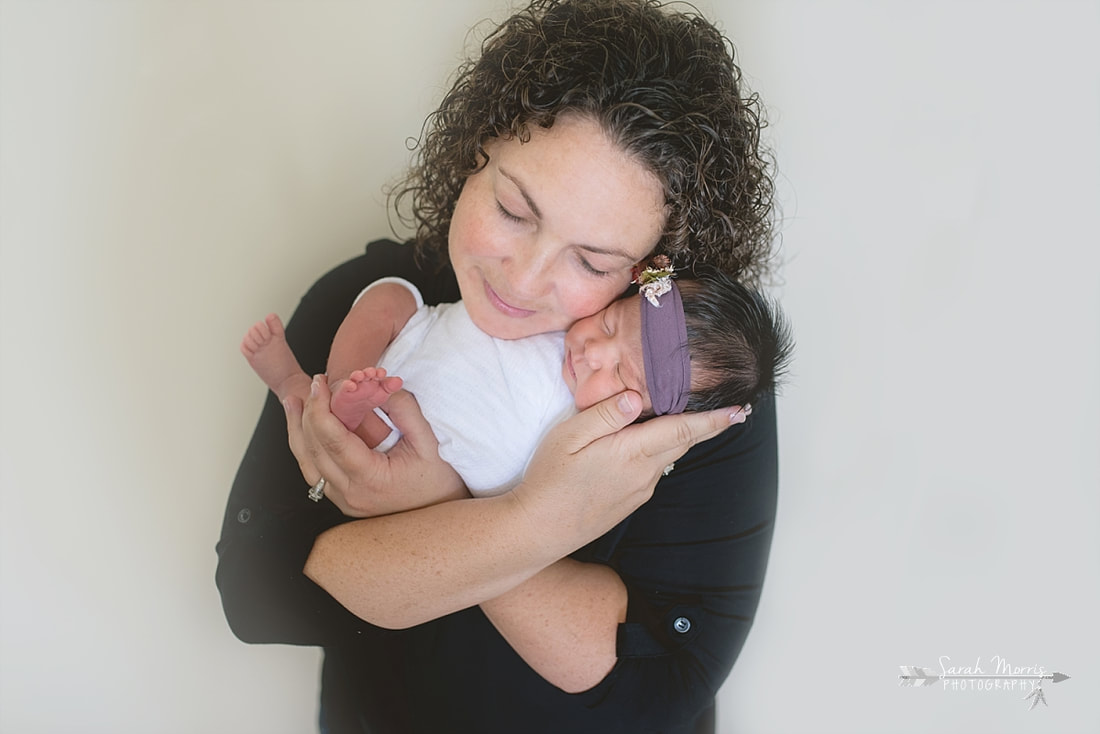 Mother holding baby girl for the lifestyle portion of her newborn photo session