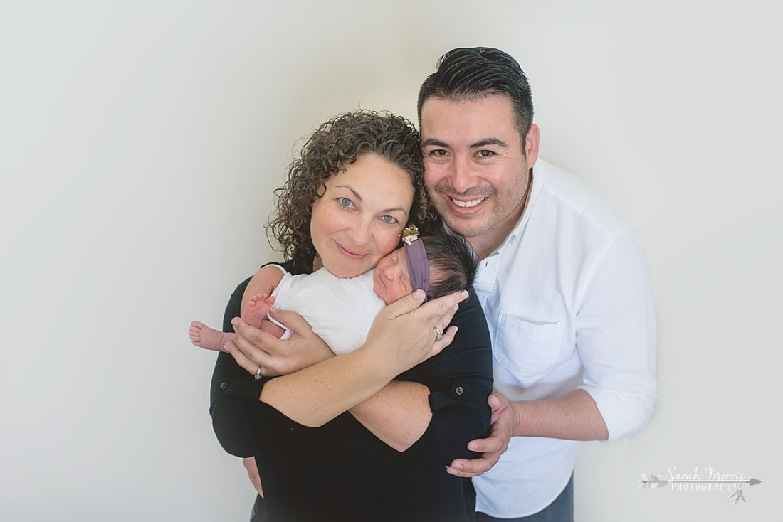Mother and Father holding baby girl for the lifestyle portion of her newborn photo session