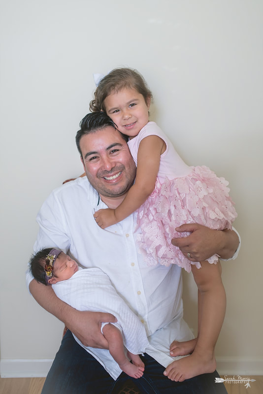 Daddy holding both daughters during the lifestyle portion of her newborn photo session
