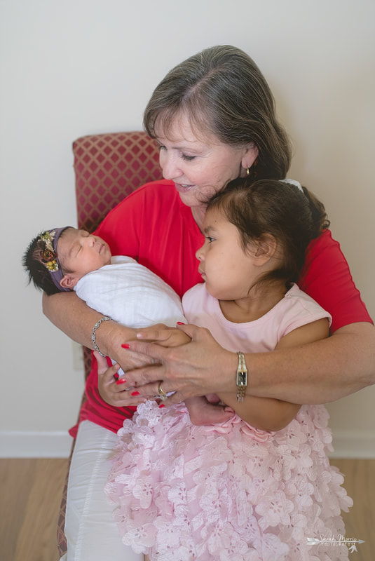 Grandma holding both granddaughters during the lifestyle portion of her newborn photo session