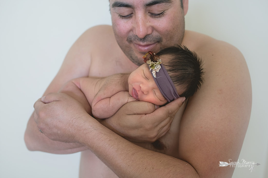 Dad holding new baby girl sking to skin during the lifestyle portion of her newborn photo session