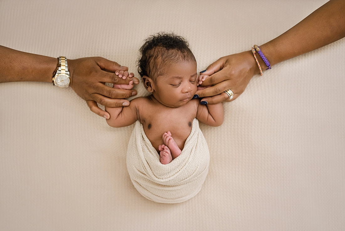 newborn baby holding mom and dad's hands for newborn session in Memphis, TN