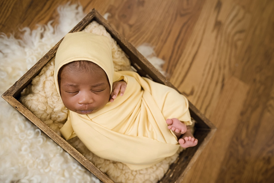 baby wrapped in yellow and sleeping in wooden box for newborn photos in Collierville, TN