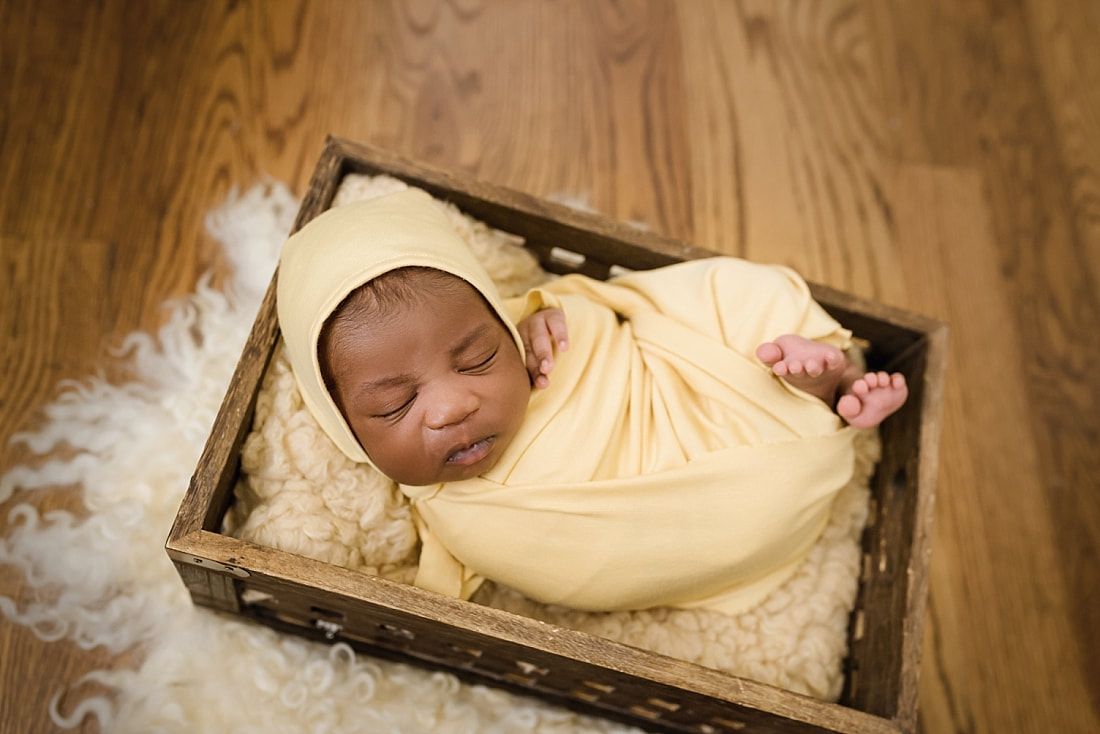 baby wrapped in yellow and sleeping in wooden box for newborn photos in Collierville, TN