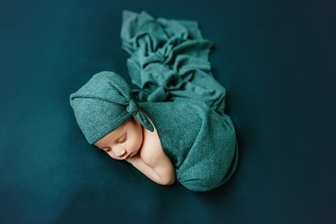 newborn baby boy posed on teal blanket for newborn photoshoot in Memphis, TN