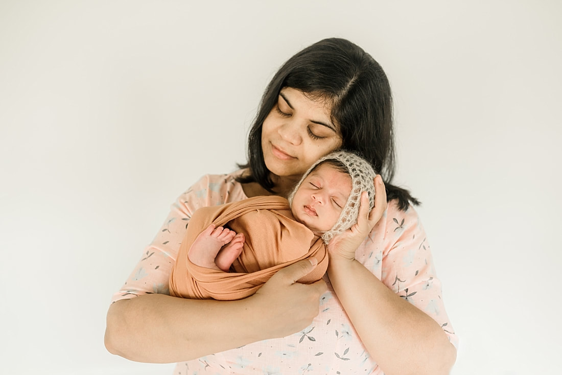 mom holding swaddled newborn baby in Memphis, TN