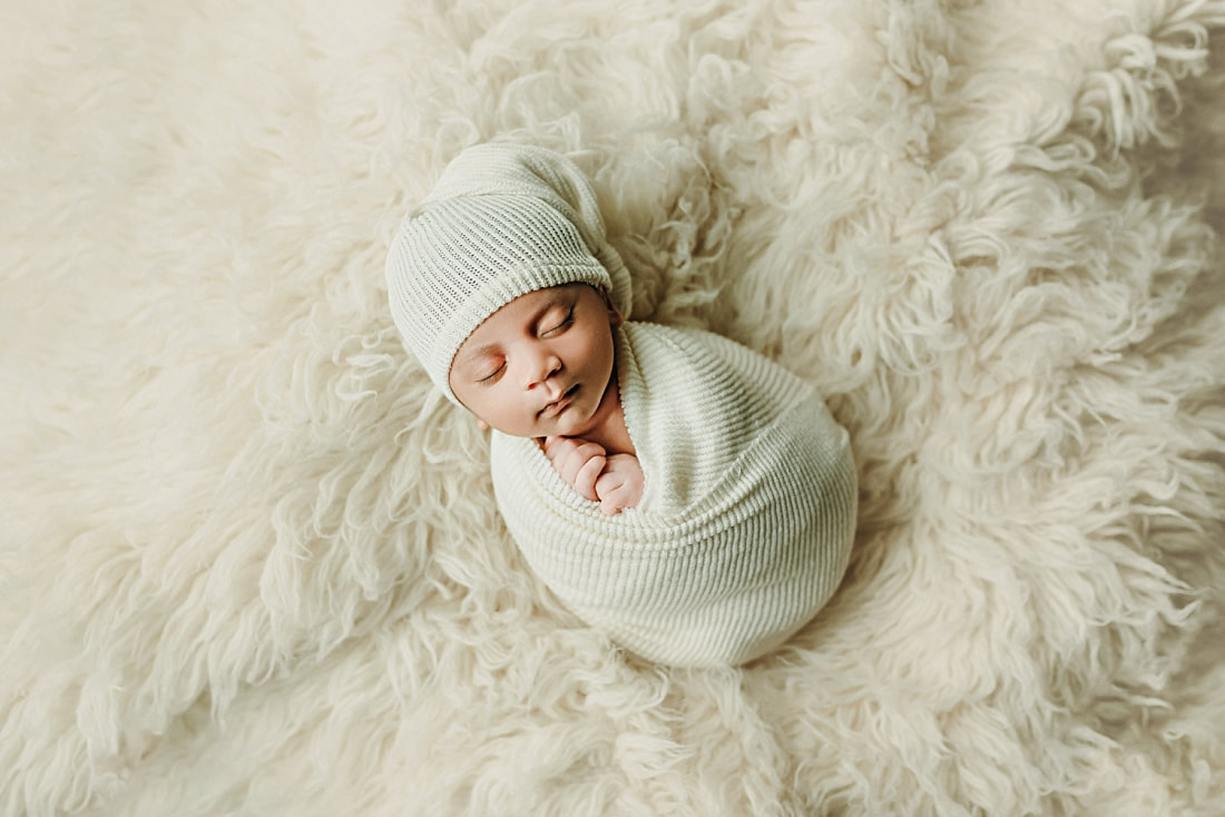 newborn baby boy wrapped in white blanket for newborn portraits in memphis, TN