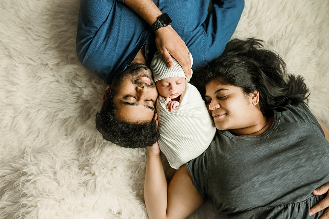 Newborn baby boy swaddled with parents for newborn portrait in Memphis, TN