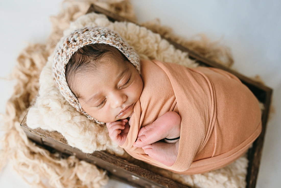 newborn wrapped in sunset orange with matching bonnet for newborn photos in memphis
