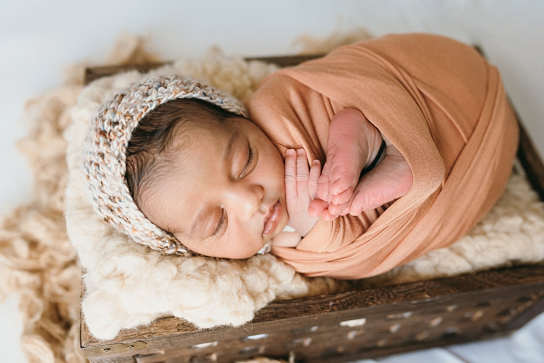 baby boy wrapped in rusty orange swaddle for newborn session in memphis
